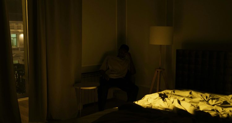 man sitting in the corner of a room