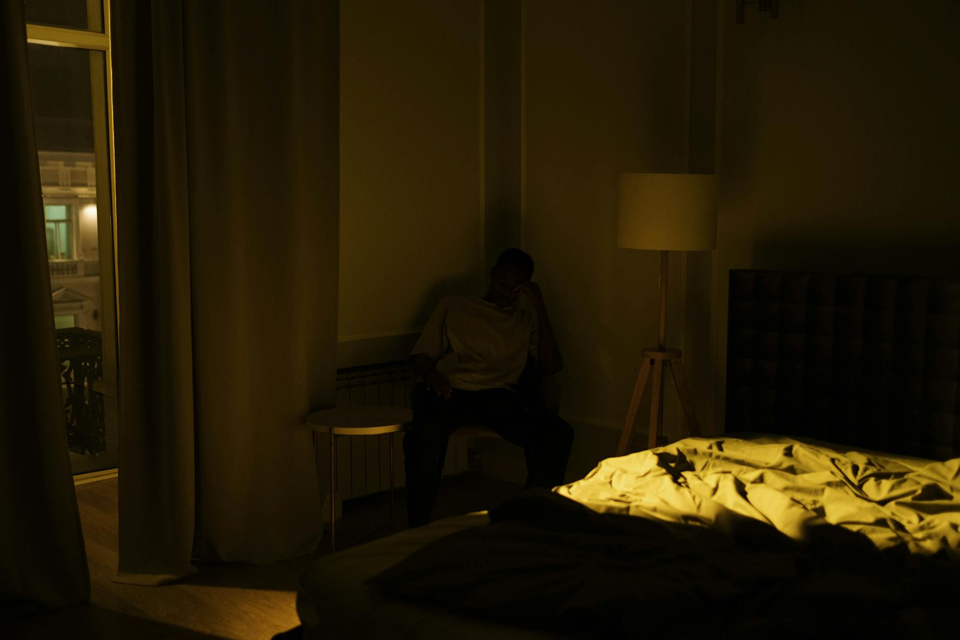 man sitting in the corner of a room