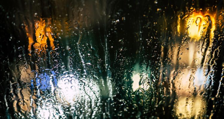 selective photography of glass window with drops of water during nighttime