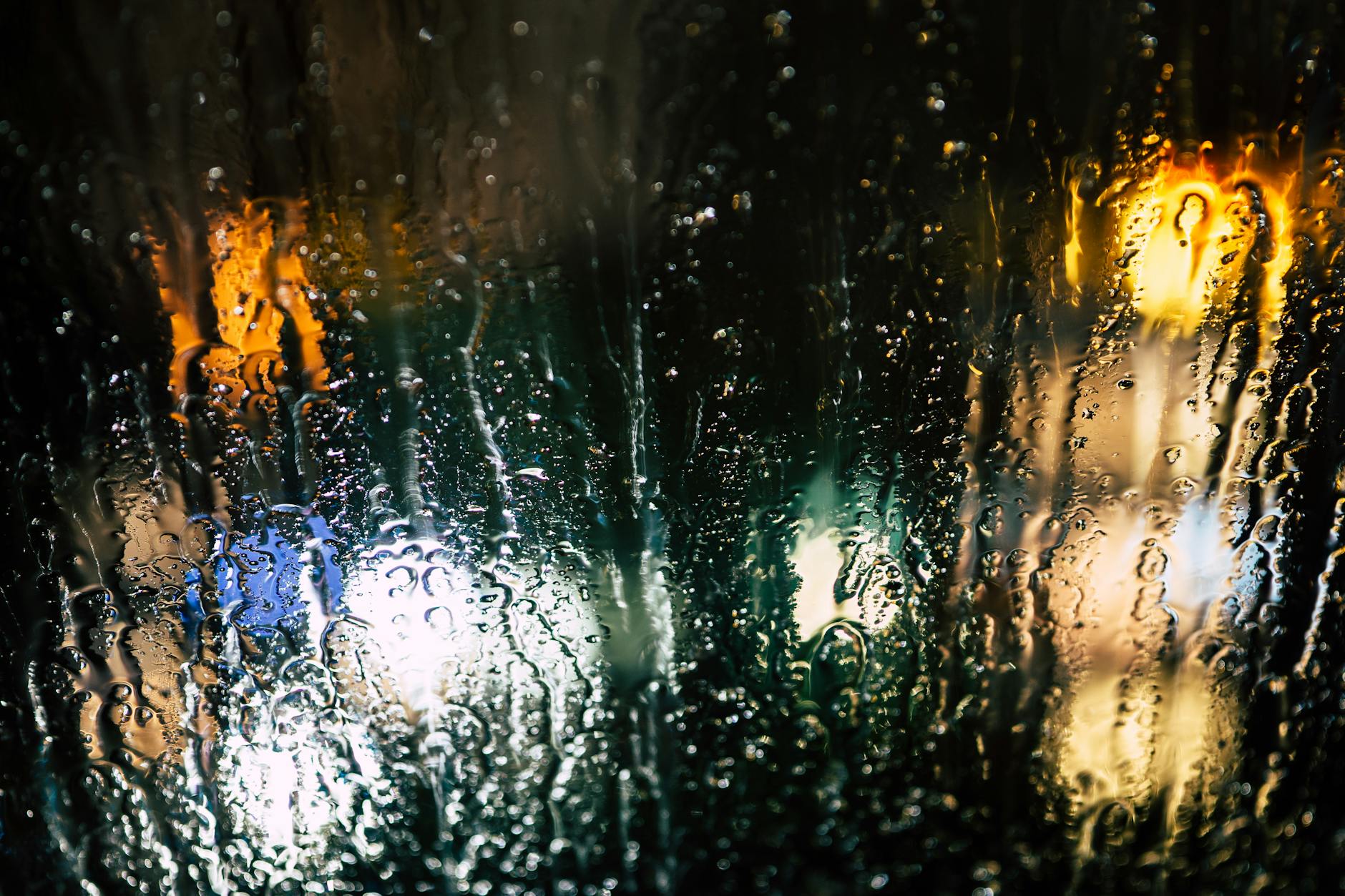 selective photography of glass window with drops of water during nighttime